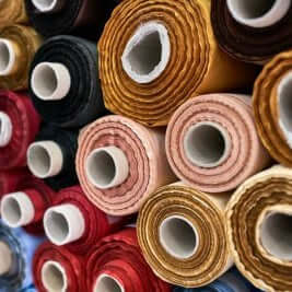 Rolled upholstery fabrics in various colors, showcasing diverse materials and textures for furniture