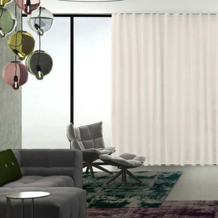 Transparante gordijnstof Solar van Kendix, De Ploeg, met subtiele schittering, in moderne woonkamer met natuurlijke lichtinval.