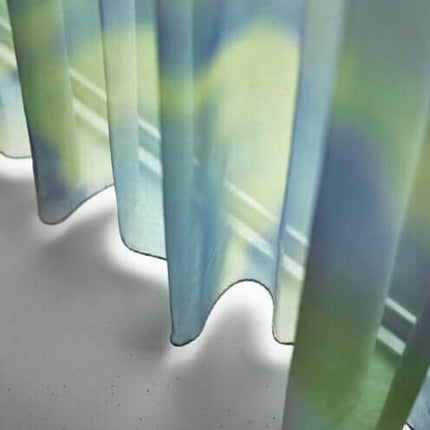 Transparante Trevira CS-stof met vloeiende blauwe en groene bewegingen, biedt privacy en lichtinval. Vanaf 5 meter 10% korting.
