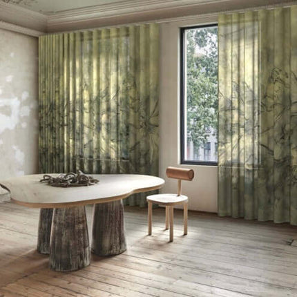 Transparante gordijnen Tempesta van Kendix met aquarel motief in een lichte kamer met houten vloer en modern meubilair.