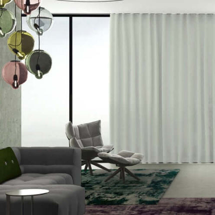 Moderne woonkamer met semi-transparante Yoko gordijnen van De Ploeg, subtiel verlicht; ideaal voor een luchtige sfeer.