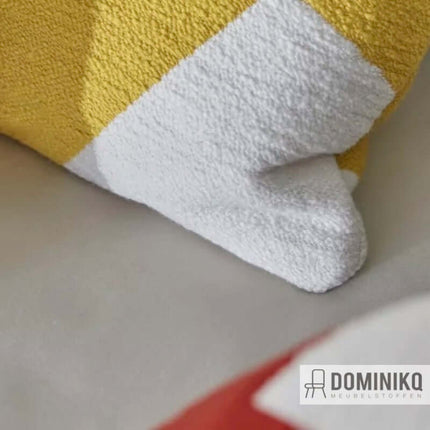 Gele en witte kussenhoek van Aristide's Agape meubelstof, geaccentueerd met een grafisch patroon en geweven met bouclé-garen.