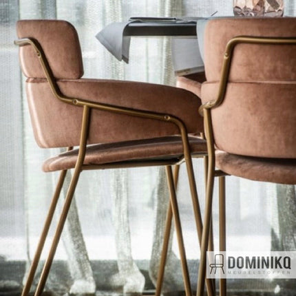 Twee stoelen met roze velvet bekleding en gouden poten naast een tafel, deel van Aristide Avalon II-collectie.