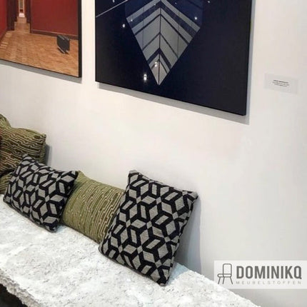 Kussens met Aristide Carlton stof met sterachtig bloemenpatroon in mozaïekstijl op een bank in een moderne interieur setting.