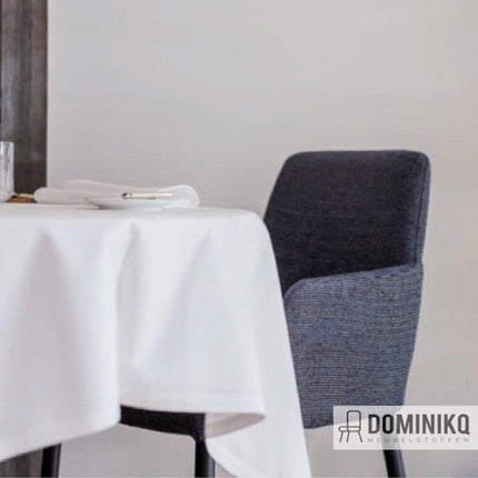 Donkergrijze eetkamerstoel bij gedekte tafel met witte tafelkleed, geïnspireerd door Aristide César meubelstof.