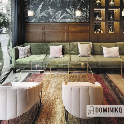 Luxe interieur met groene Aristide Troy bank en moderne stoelen in woonruimte