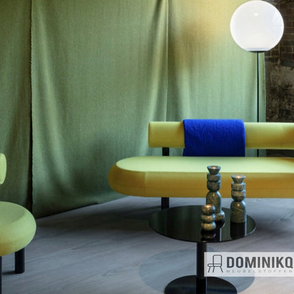 Stijlvolle bank met groene Bute Fabrics Magic CF1105 stof in moderne woonkamer, zonder Dominikq Meubelstoffen watermerk.