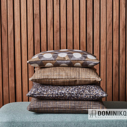 Gestapelde kussens met Camira Patternmaker Hula PMH04 stof, gemaakt van 100% wol, op een houten achtergrond.