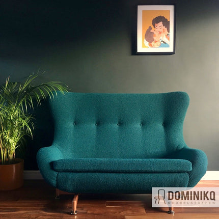 Groene vintage fauteuil bekleed met Magic CF1105 stof van Bute Fabrics, geplaatst in stijlvolle woonkamer met planten en retro kunstwerk.