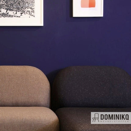 Twee fauteuils bekleed met Bute Fabrics Alchemy CF1012 stoffen in neutrale tinten, tegen een donkerblauwe muur met kunstwerken.