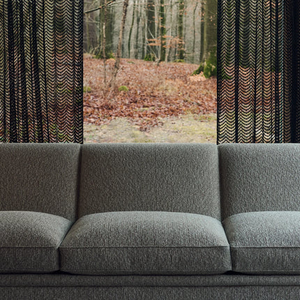 Kvadrat - Sahco - Nalia - 630 fabric on grey sofa with forest view through curtains, showcasing contrasting and complementary yarns.