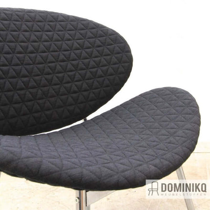Een stoel bekleed met Triangle meubelstof van Kvadrat en Febrik, ontworpen door Bertjan Pot, met een geometrisch driehoekig patroon.
