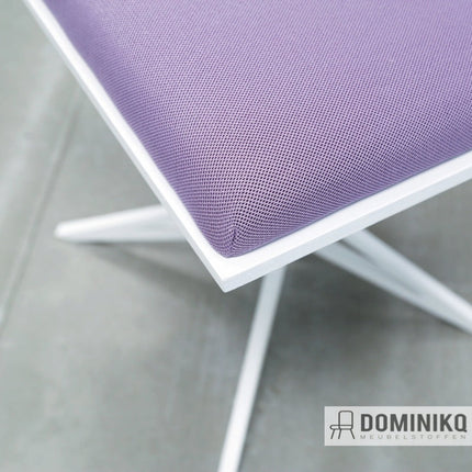 Paarsgevlekt Harlequin textiel op moderne stoel, ideaal voor klassieke en minimalistische meubelstijl.
