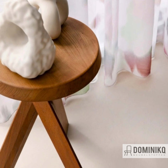 Pixelbloom gordijnstof met bloemenmotief achter houten bijzettafeltje en keramische decoratie, perfect voor een luchtig interieur.