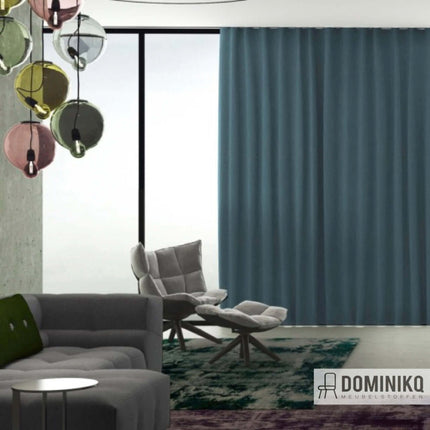 Blauwe gordijnstof Ori van Kendix, De Ploeg, in elegante woonruimte met moderne meubels en stijlvolle verlichting. Vanaf 5 meter 10% korting.