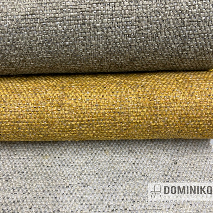 Twee rollen Keymer Admire stof in verschillende kleuren tonen duurzaamheid en comfort, geschikt voor stoffering met gerecycled materiaal.