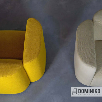 Twee fauteuils bekleed met kleurrijke Kvadrat Febrik Drop stofserie. Links geel, rechts neutrale tint op grijze achtergrond.