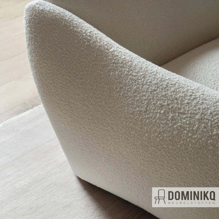 Close-up van Elle bouclé stof in crème kleur op een moderne stoel, zachte textuur voor interieurontwerp.