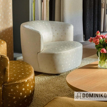 Elegante draaifauteuil in de woonkamer, bekleed met Saji-stof van Kvadrat Sahco in een klassiek jacquardpatroon.