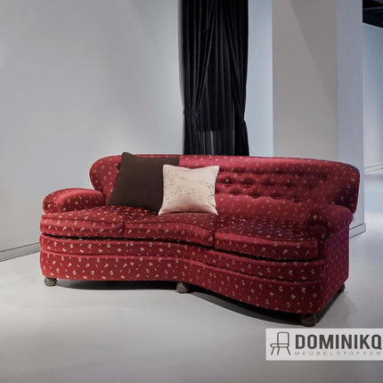 Stijlvolle rode bank met klassiek jacquardpatroon, geschikt voor eigentijds interieurdesign, gefotografeerd in moderne showroom.