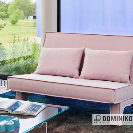 Roze bank bekleed met Steelcut Beat stof door Kvadrat, omgeven door glazen wanden en groene omgeving.