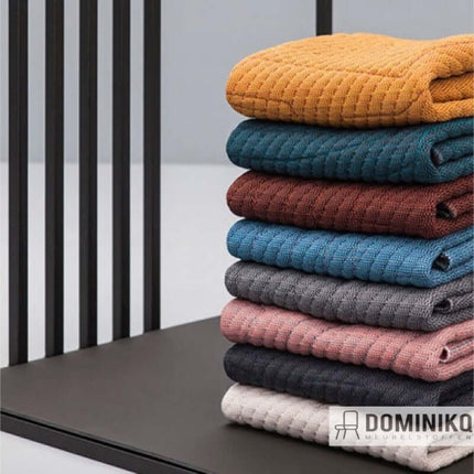 Gestapelde gebreide meubelstoffen van Kvadrat Febrik in diverse kleuren, ontworpen door Textielstudio BYBORRE in Amsterdam.