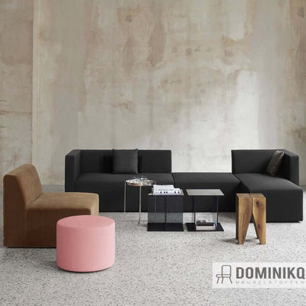 Moderne woonkamer met Kvadrat Raf Simons Byram meubilair in donkere en roze tinten, voorzien van elegante stoffen en design.