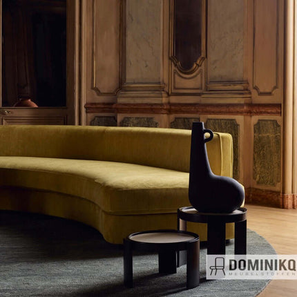 Stijlvolle woonkamer met gele sofa bekleed met Sahco Nabis stof en moderne bijzettafels. Interieur met klassieke en moderne elementen.