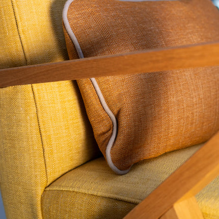 Oranje Vescom Fuga kussen op gele stoel, decoratieve stof van 100% polyester met subtiele textuur, interieurdesign accent.