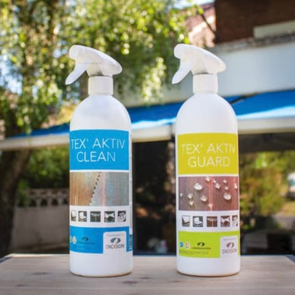 Twee flessen Tex Aktiv Clean en Guard voor het reinigen en beschermen van outdoor stoffen van Sunbrella op een houten tafel.