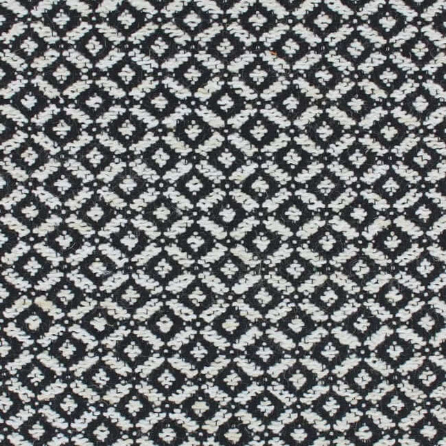 Aristide Varga meubelstof met zwart geometrisch patroon, subtiel en elegant, met herhaling van 2,1x2,3 cm voor harmonieus interieur.