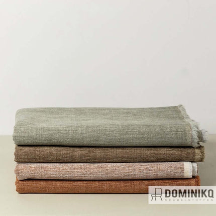 Stapel van De Ploeg meubelstoffen in warme aardetinten, inclusief Mos stof, verkrijgbaar bij Dominikq Meubelstoffen.