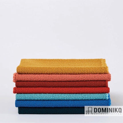 Verschillende kleuren bouclé meubelstoffen gestapeld, Camira Fabrics Yoredale collectie, symboliseert Yorkshire erfgoed.