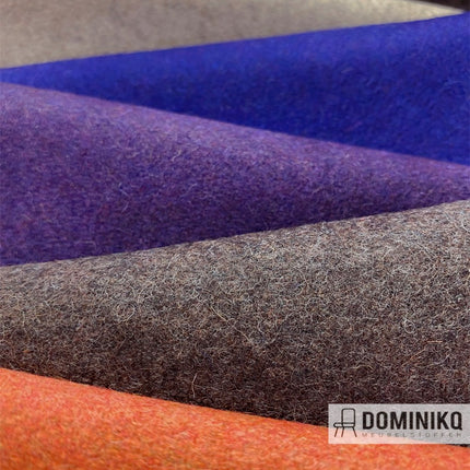 Close-up van Casal Dolly woontextiel met viltoppervlak in diverse warme kleuren, inclusief oranje, paars en grijs tinten.