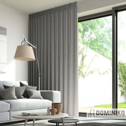 Moderne woonkamer met grijze gordijnen van De Ploeg, stijlvolle inrichting en natuurlijke lichtinval. Comfortabel en elegant design.