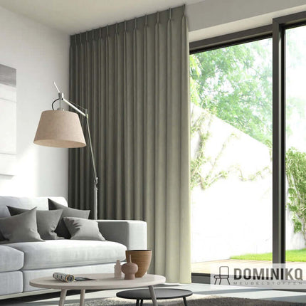 Moderne woonkamer met grijze gordijnen van natuurlijke vlamvertragende stof en uitzicht op een groene tuin. Vanaf 5 meter 10% korting.
