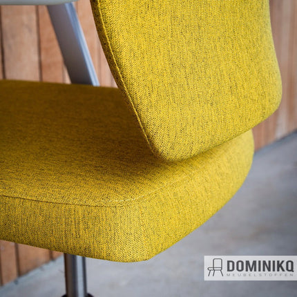 Stijlvolle gele stoel bekleed met duurzame Noma stof van gerecycled polyester, perfect voor werkruimtes en interieurs.