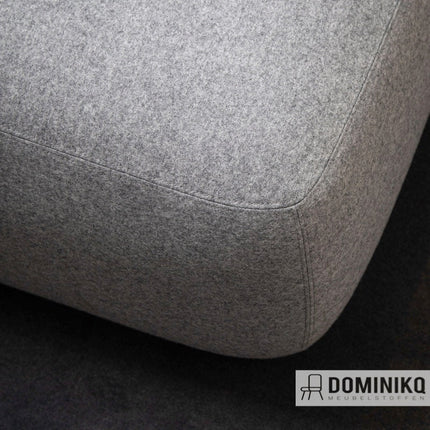 Grijze geweven stof Focus Melange, 100% kamgarenwol, met zijdezachte touch en modern design op meubel.