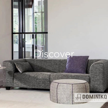 Grijze bank bekleed met Keymer Discover meubelstof met paarse kussens in moderne woonkamer.