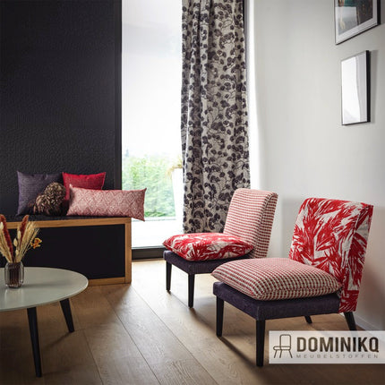 Interieur met stoelen bekleed met Casal Montero stof met tropische palmprint, naast gordijn en zitbank. Modern ontwerp met diepte-effect.