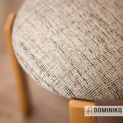 Geweven stof Nubis 72 van De Ploeg op houten stoel, duurzame en zachte textielkeuze voor woonkamers en slaapkamers. Vanaf 5 meter 10% korting.