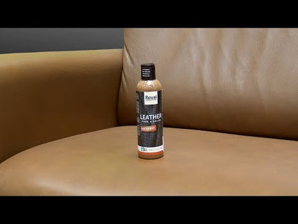 Lederverzorgingscrème Royal Furniture 250 ml, geschikt voor kleurherstel en onderhoud van diverse leersoorten, zittend op een leren bank.